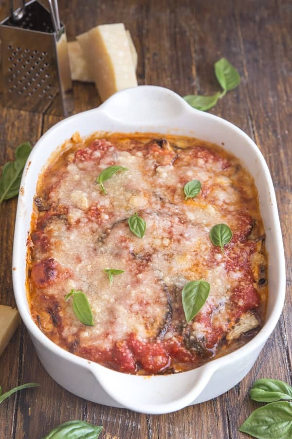 Baked eggplant parmesan in a white baking dish.