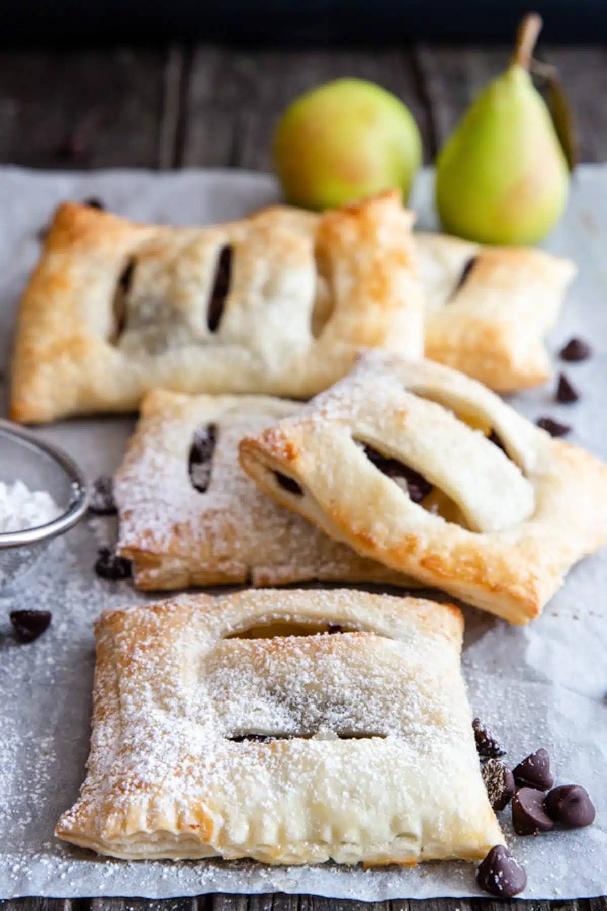 Pear and chocolate pastries on parchment paper.
