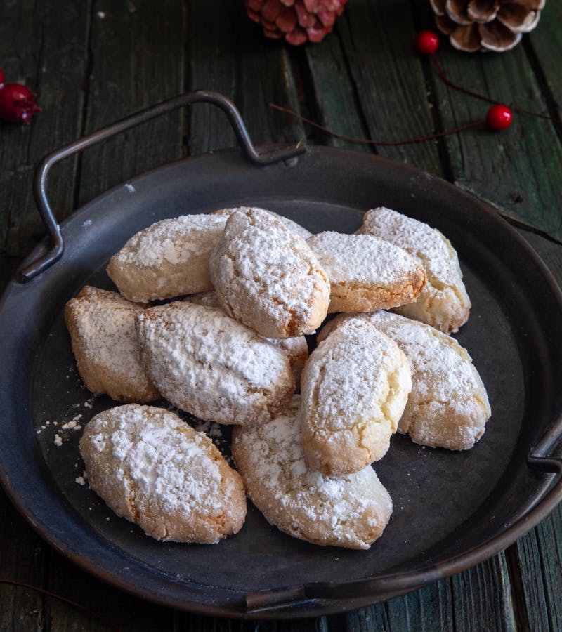 Ricciarelli cookies on a black plate.