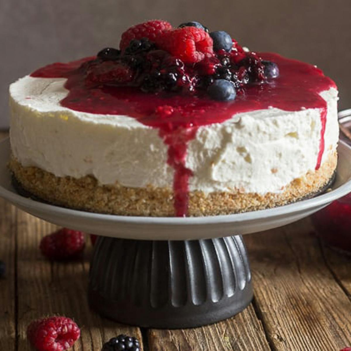 Berry Cheesecake on a cake stand.