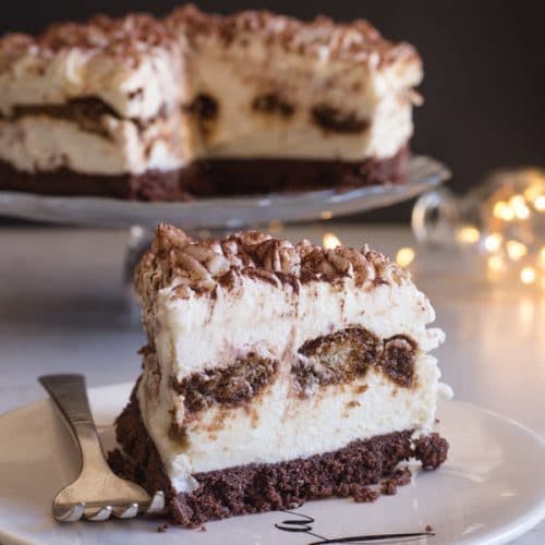 A slice of tiramisu cheesecake on a white plate.