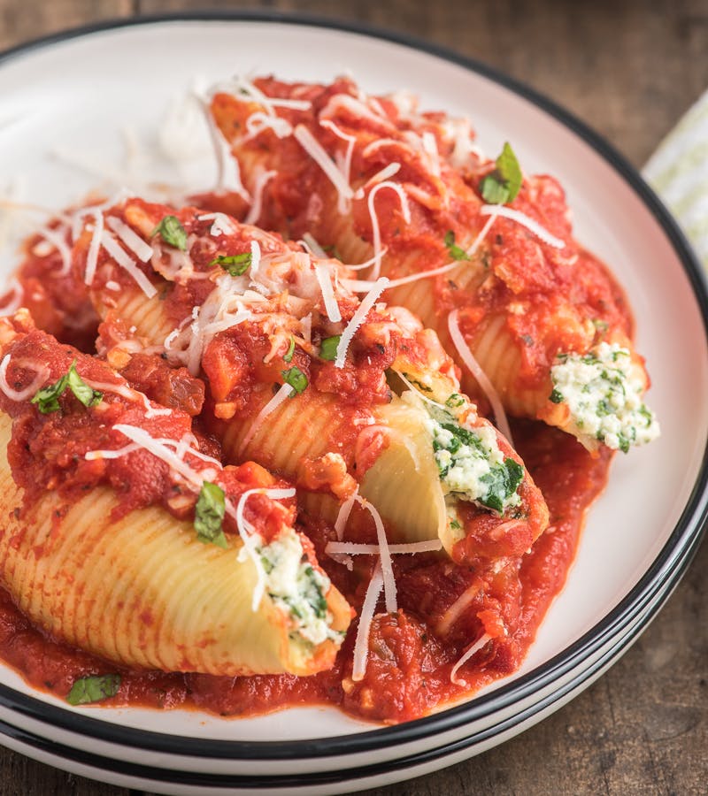 3 stuffed pasta shells on a white plate.