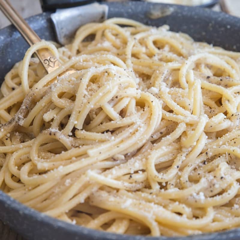 Authentic cacio e pepe in a black pan.