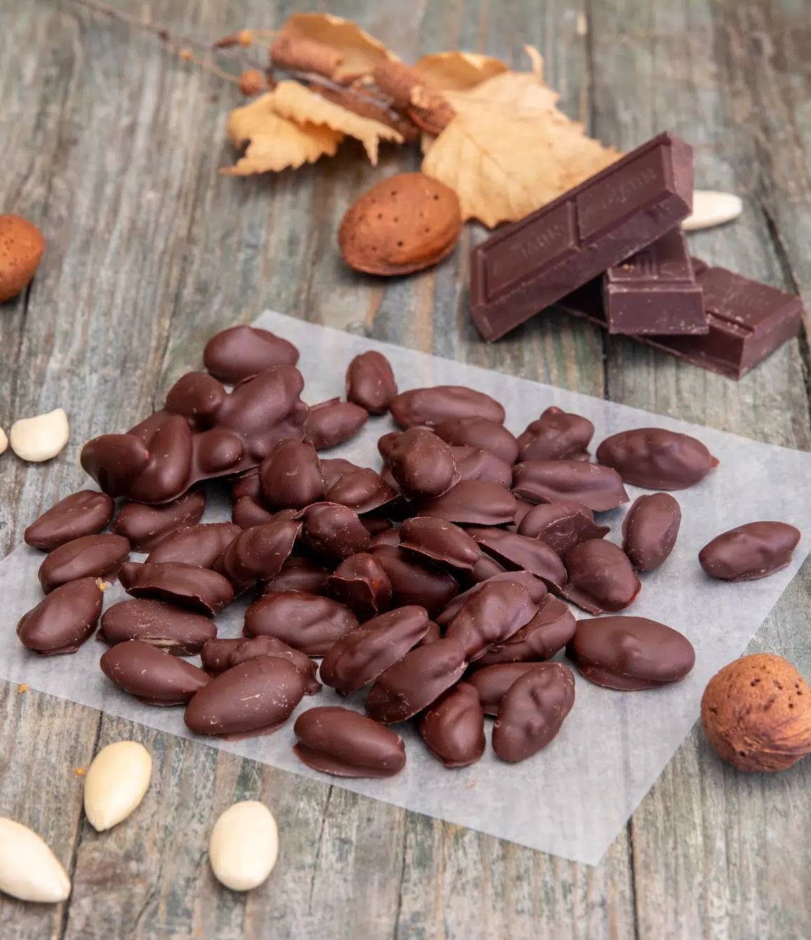 Chocolate covered almonds on parchment paper.