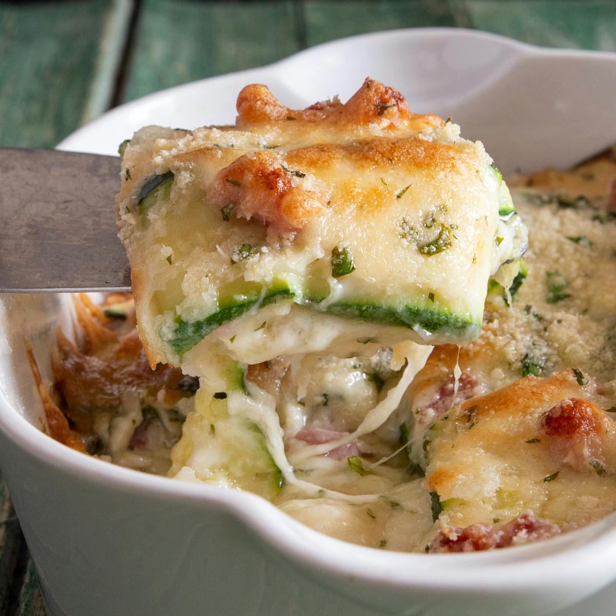 A slice of zucchini parmesan on a cake server.