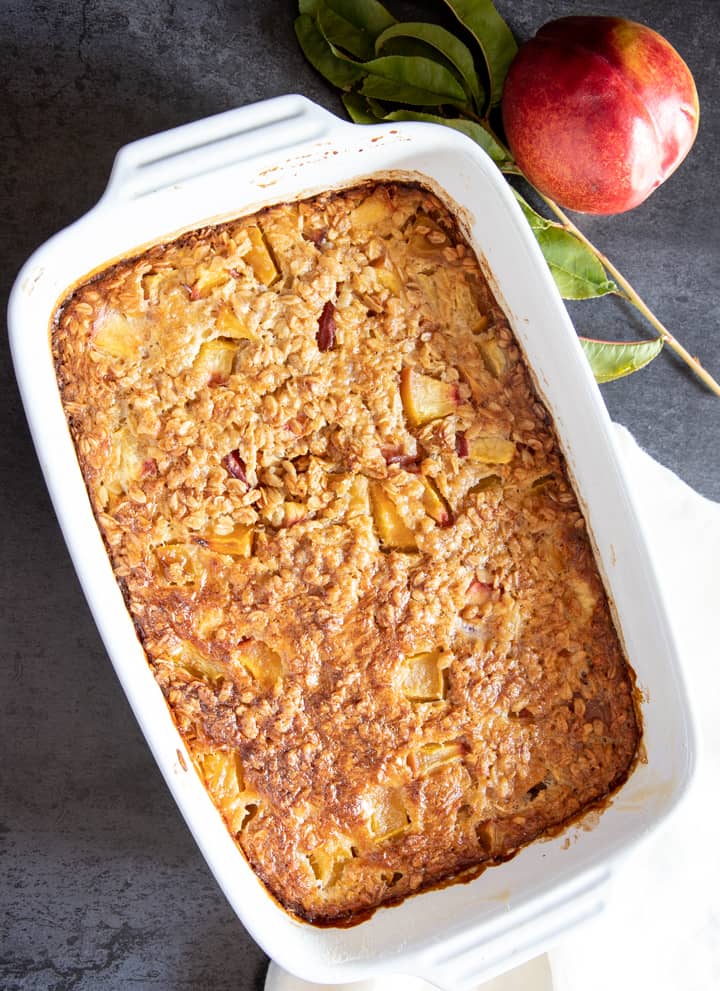 Peach baked oatmeal in a white pan.