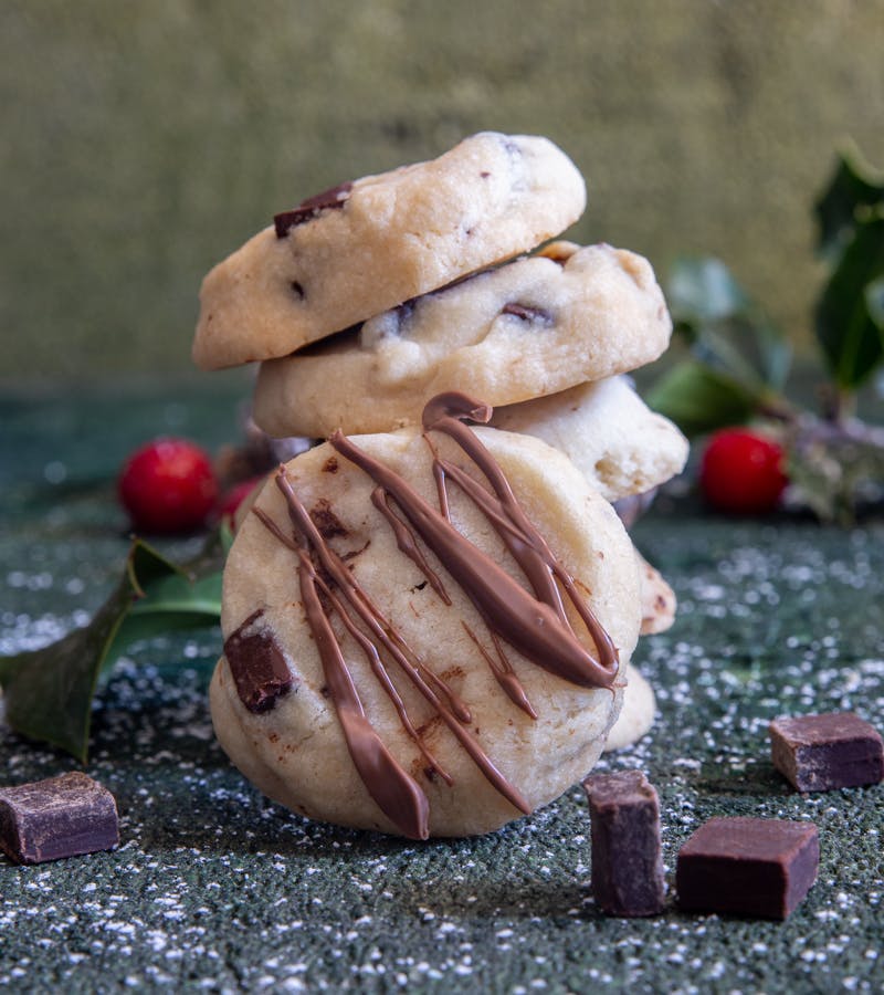 4 chocolate chip shortbread cookies stacked with 1 leaning.