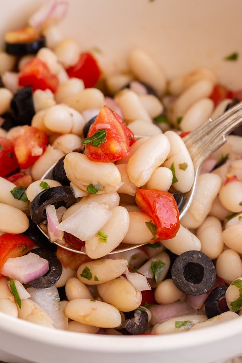 White bean salad with some on a spoon.