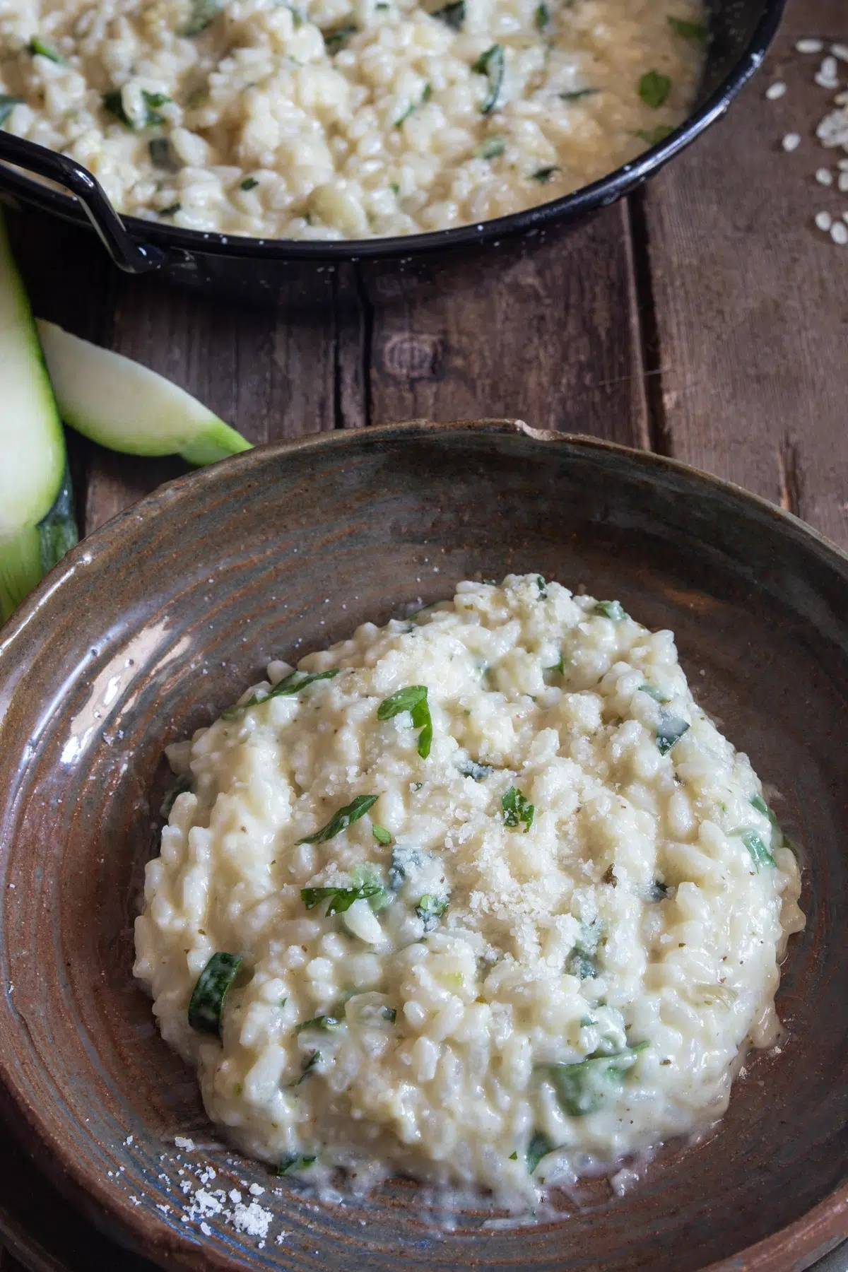 Zucchini risotto in a pan and some on a plate.