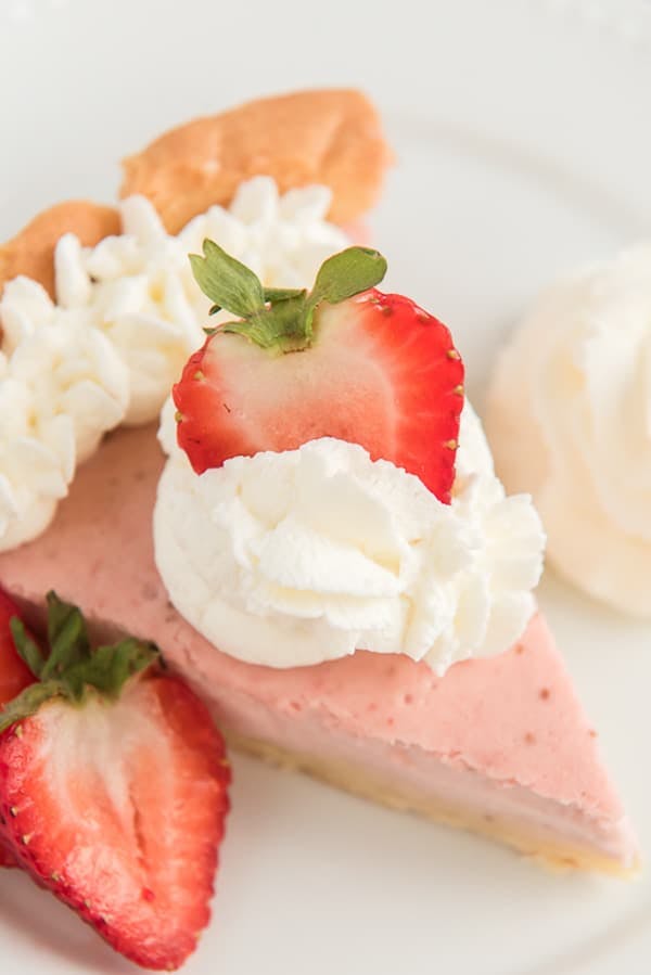 A slice of strawberry cheesecake pie on a white plate.
