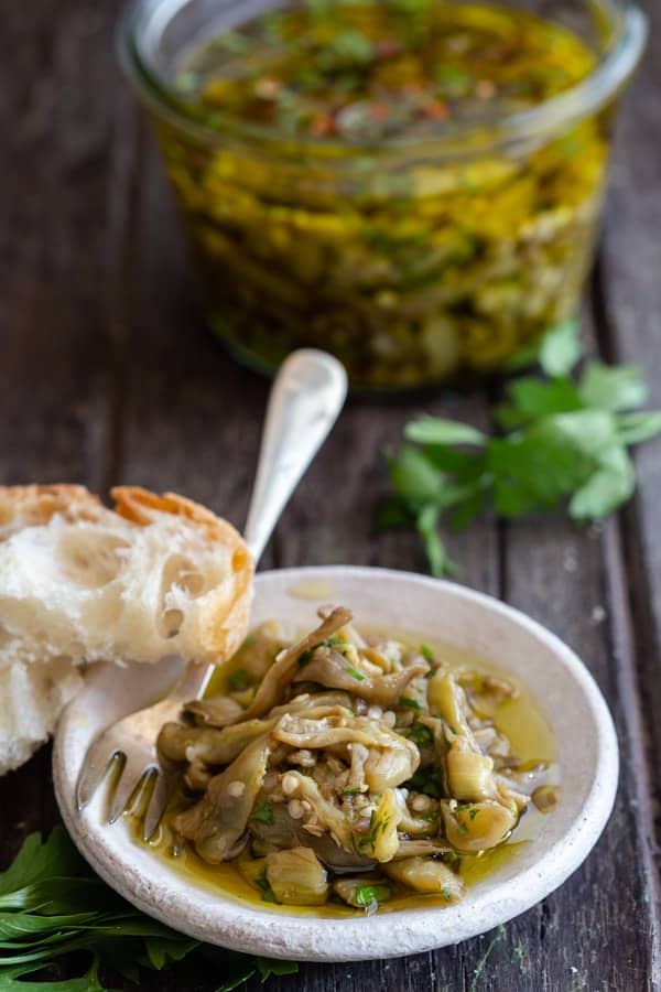 Pickled eggplant in a white dish and a jar.