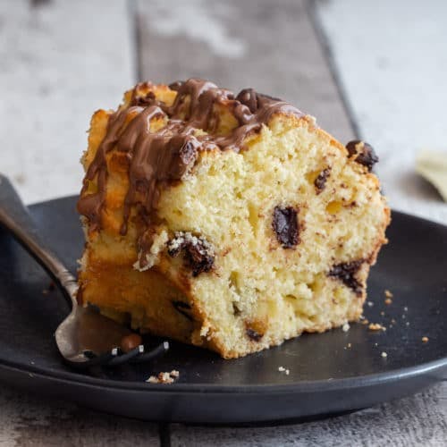 A slice of cake on a black plate.