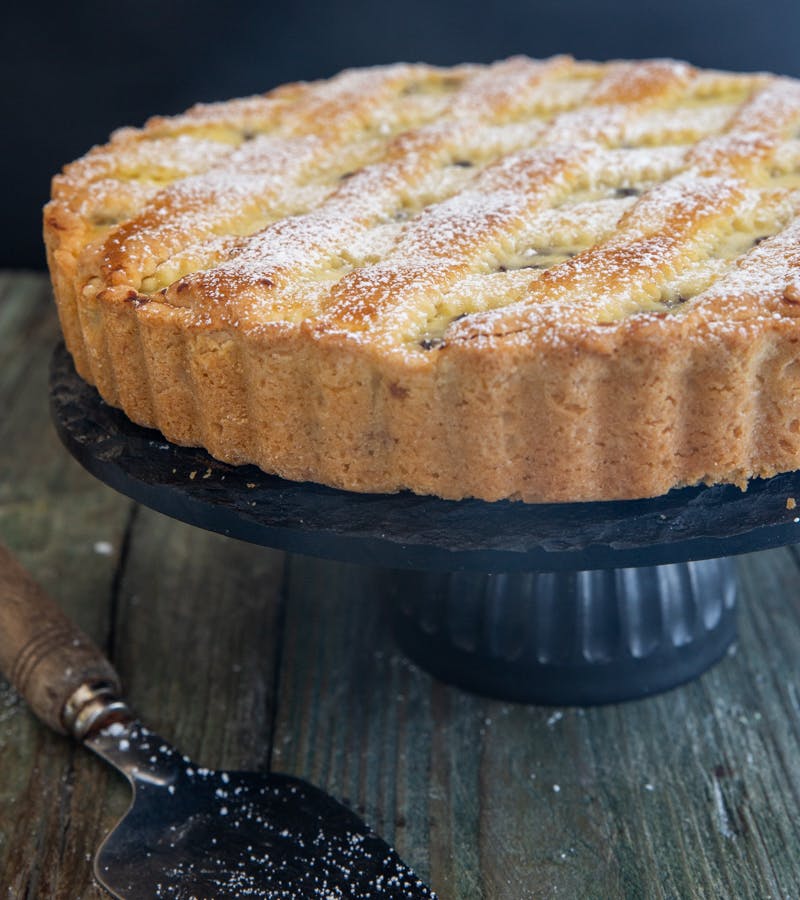 Roman ricotta crostata on a black plate.