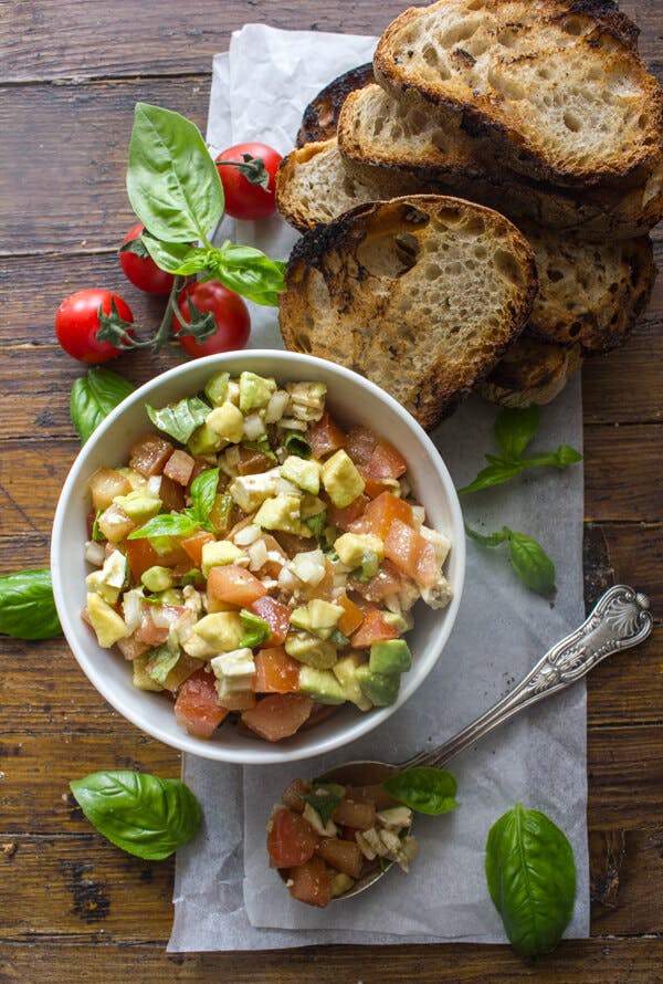 Grilled bread & avocado mixture in a white bowl.