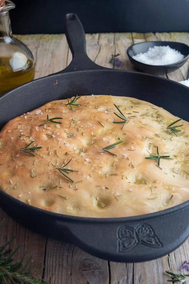 Sourdough focaccia in a black pan.