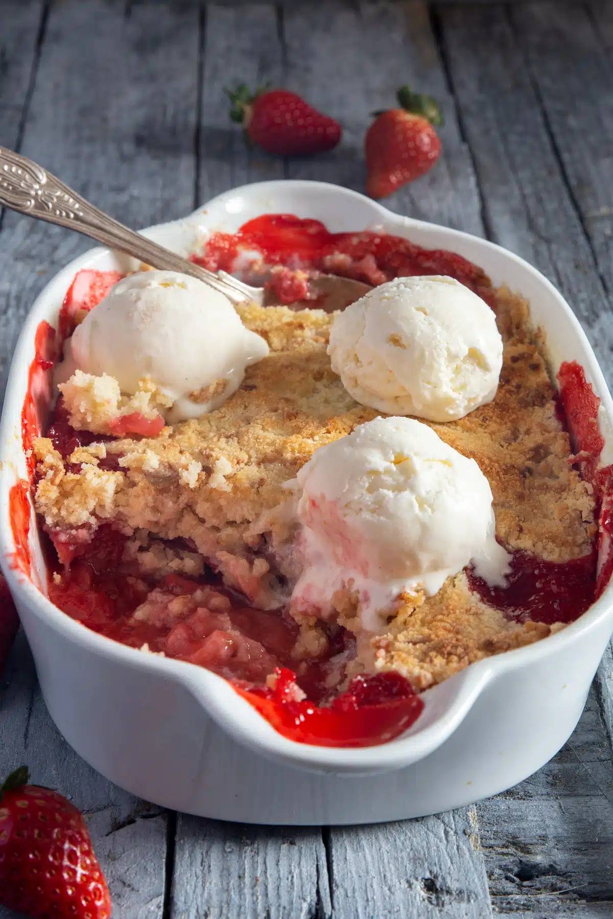Strawberry crumble in a white pan.