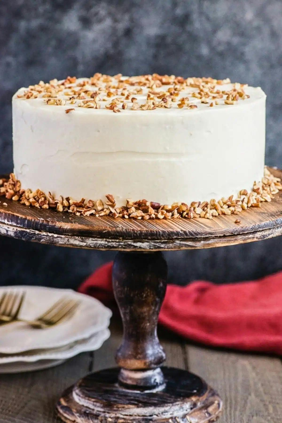 Carrot cake on a wooden cake stand.