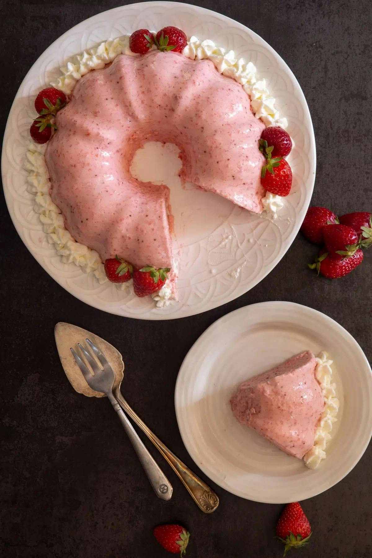 Strawberry bavarese on a plate and a slice on a white plate.