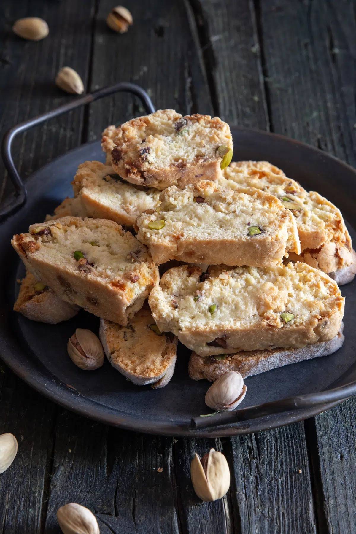 Pistachio biscotti on a black dish.