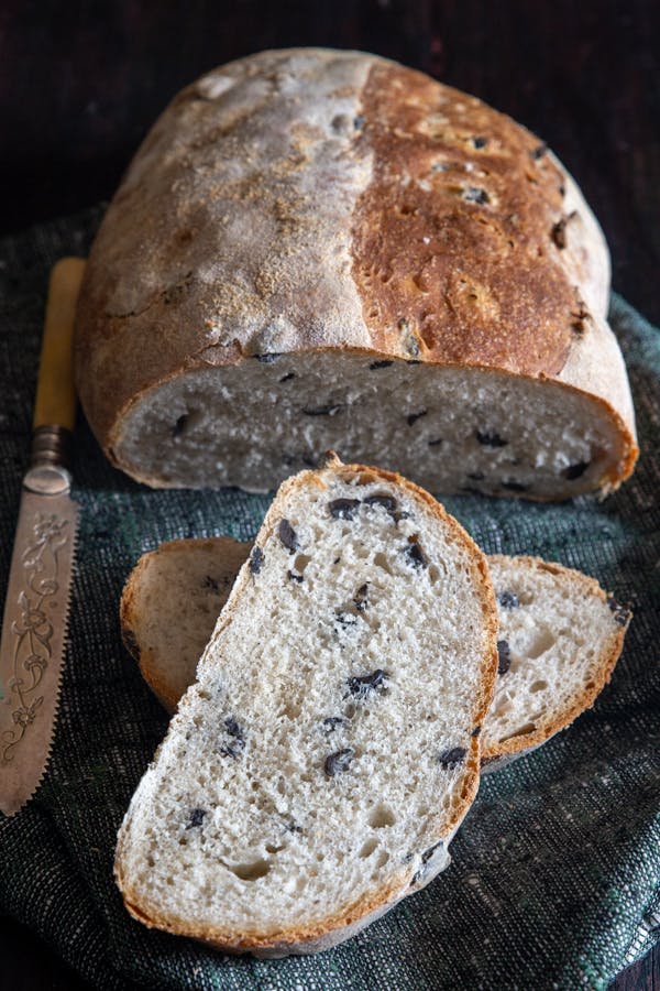 Olive loaf with 2 slices cut.