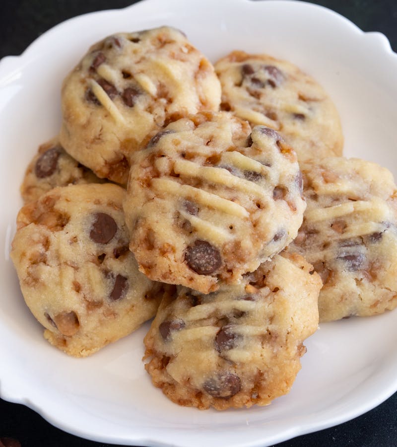 Chocolate toffee shortbread cookies on a white plate.