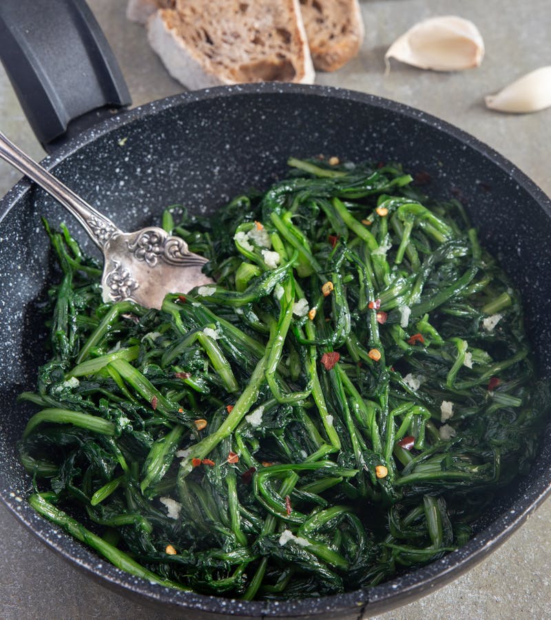 Italian sauteed chicory greens in a black pan.