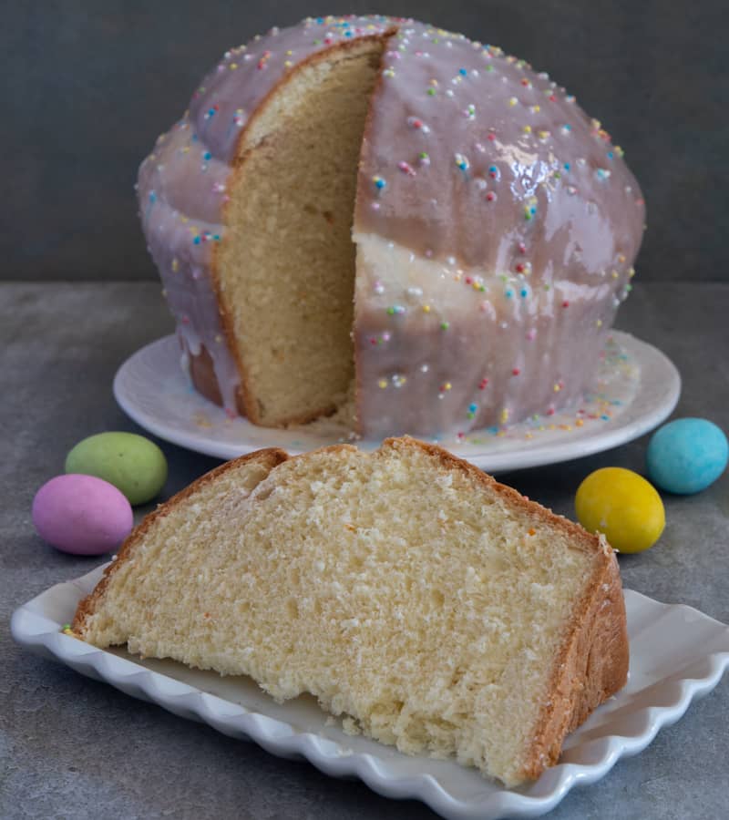 Roman Easter sweet bread on a white plate with a slice on a white plate.