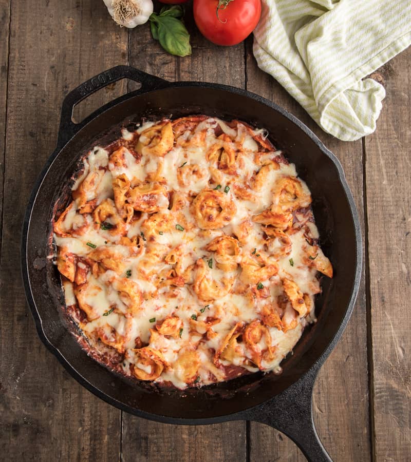 Baked tortellini in a black pan.