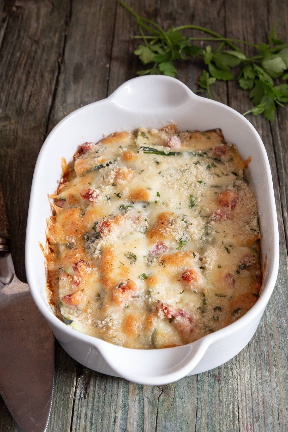 Zucchini parmesan in a white dish.