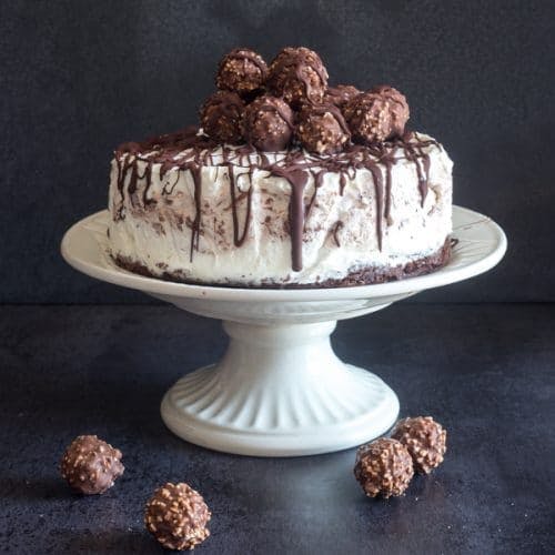 Ice cream cake on a white cake stand.