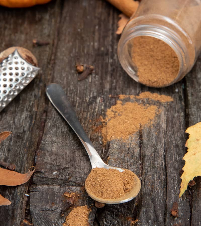 Pumpkin pie spice on a spoon and in a jar.