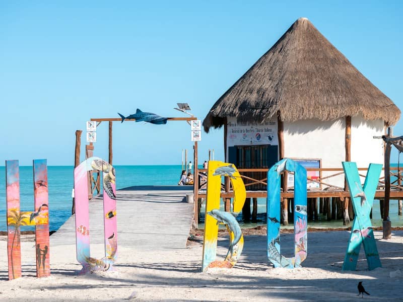 Colorful letters spell out holbox by a beach hut