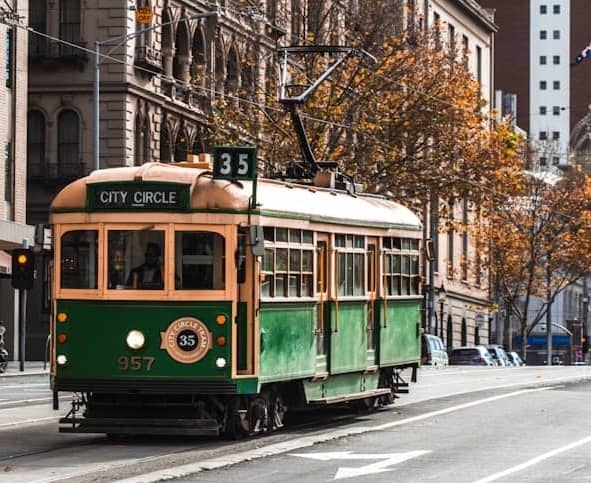 green and yellow tram on road during daytime