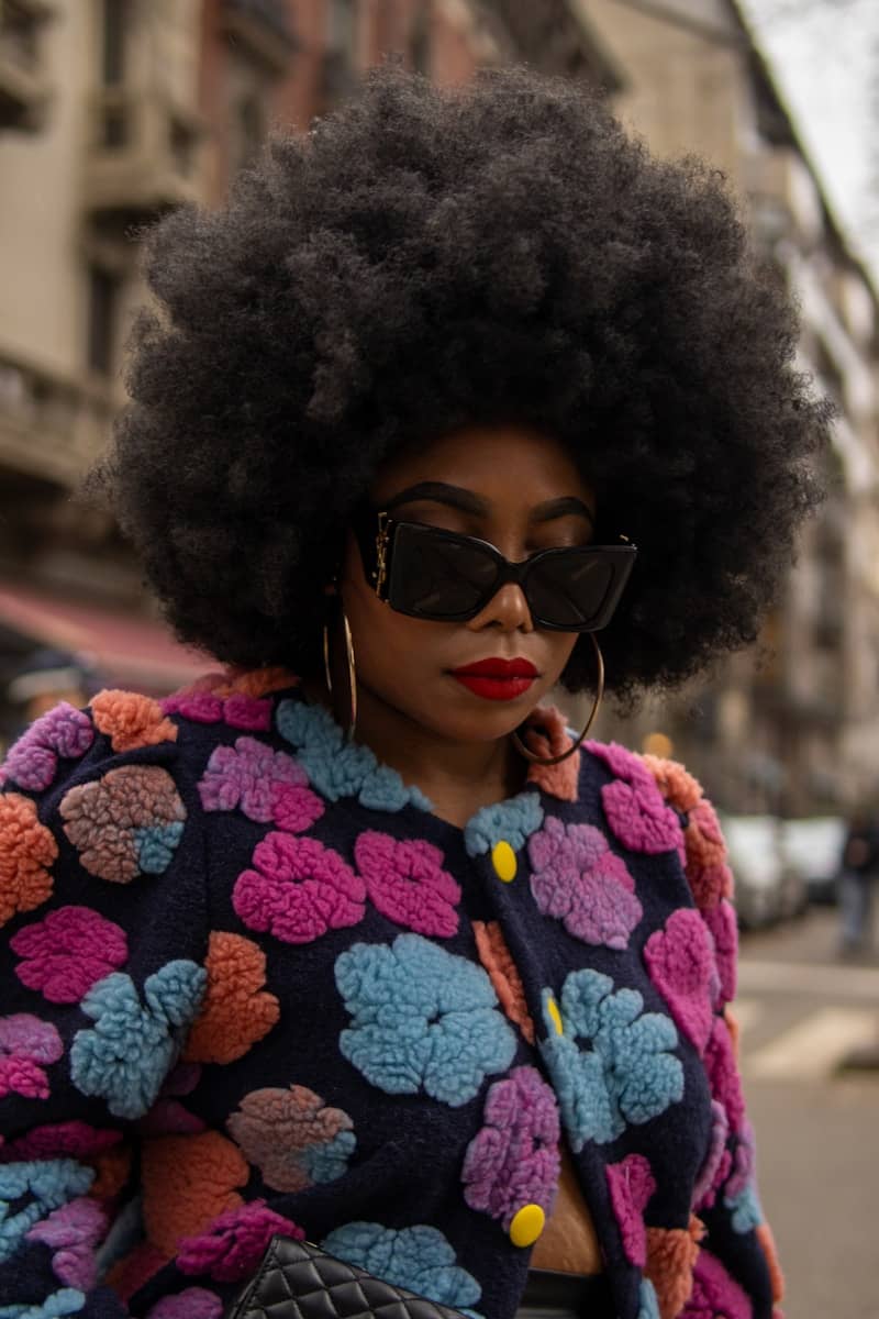 A woman with an afro is walking down the street