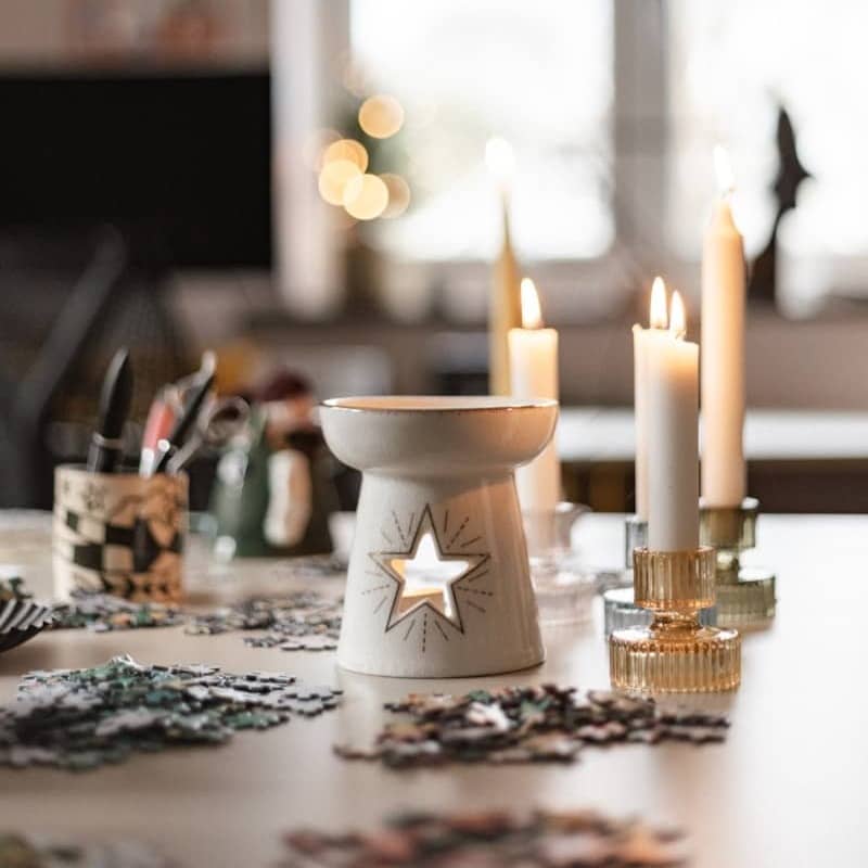 A table topped with lots of candles next to a window