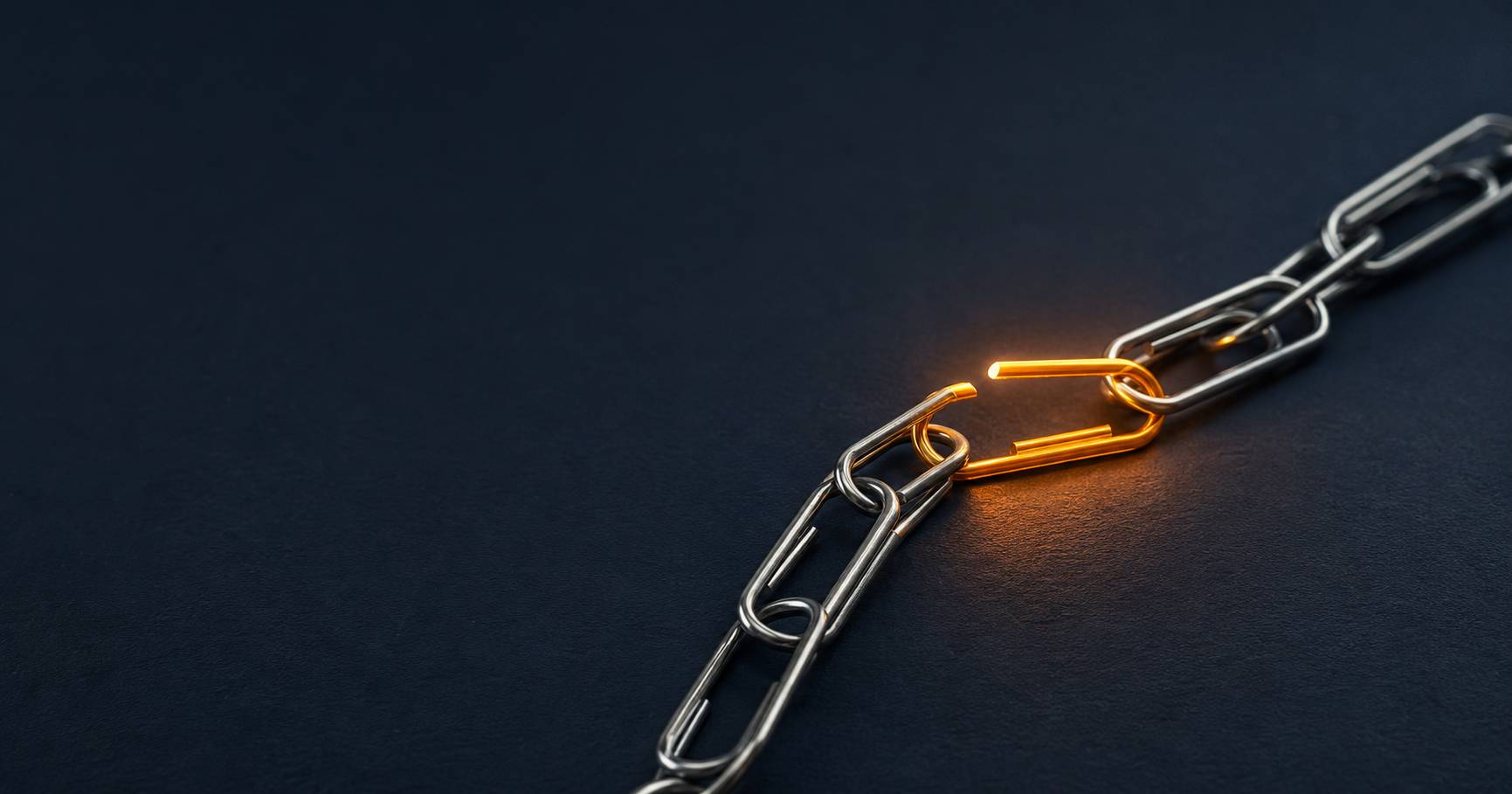 Eine gesprengte Kette aus Büroklammern auf tiefblauem Grund, ein Glied leuchtet bernsteinfarben, Symbol für die Befreiung von manueller Report-Arbeit.