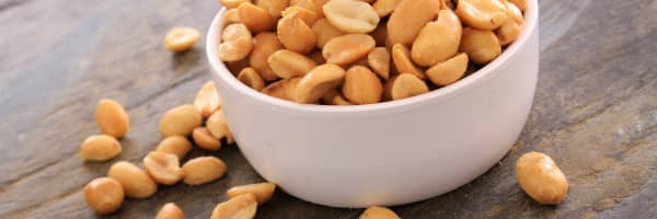 a white bowl filled with peanuts