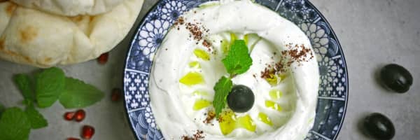 a blue dish with labneh and mint and spices