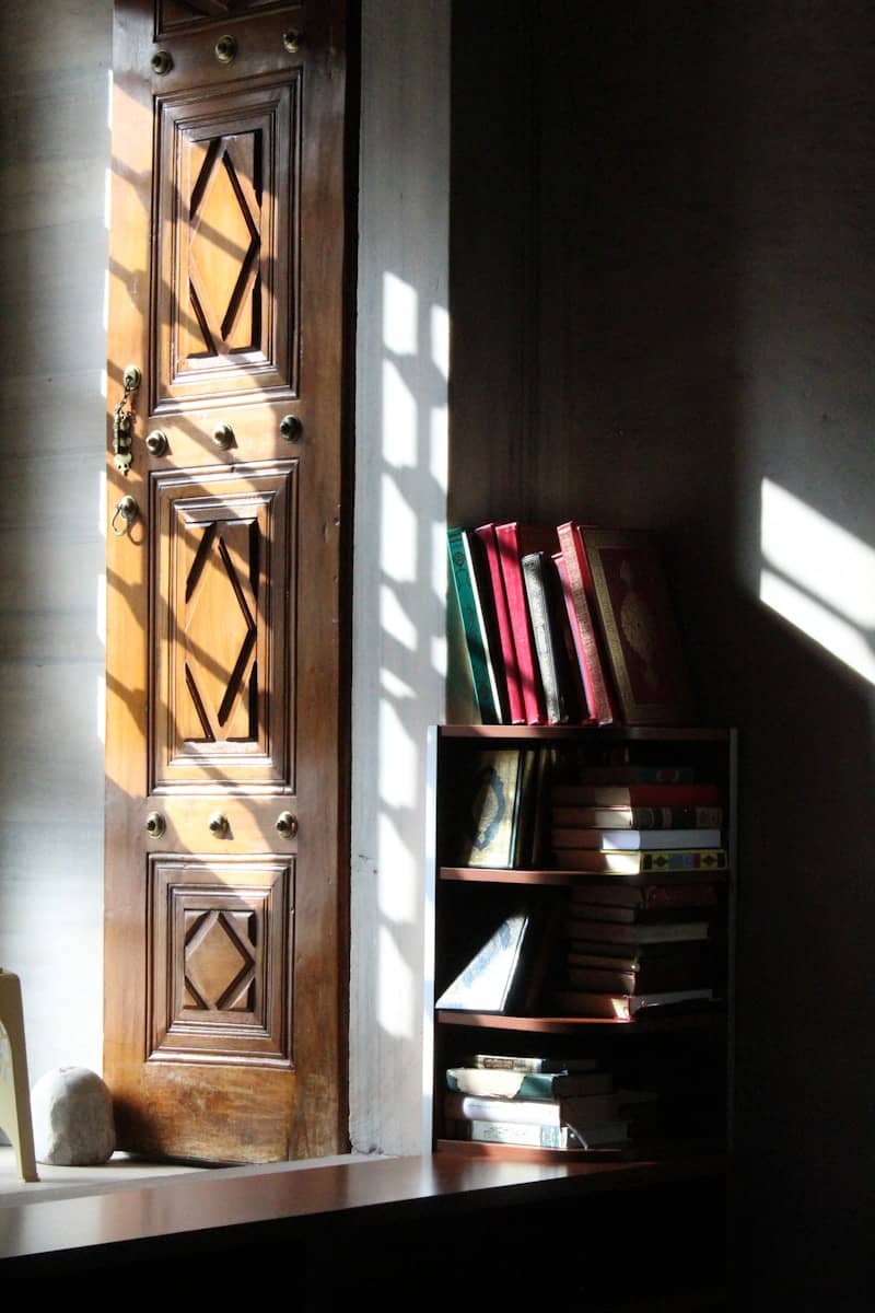 Sunlight streams through a door onto books.