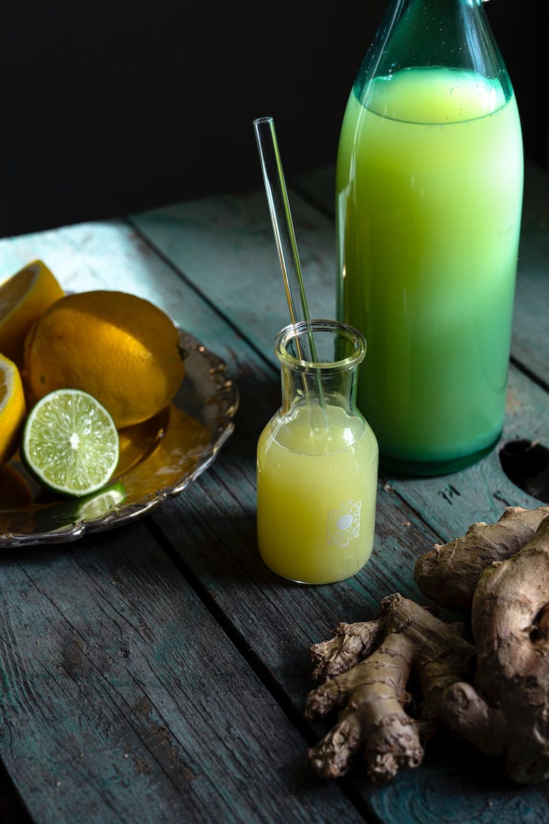 sliced lemon beside clear glass jar with green liquid