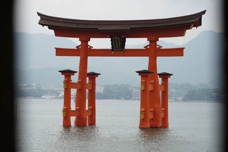 A large orange gate in the middle of a body of water