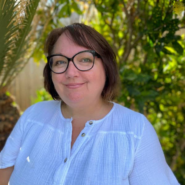 Photo of Jo in front of garden foliage