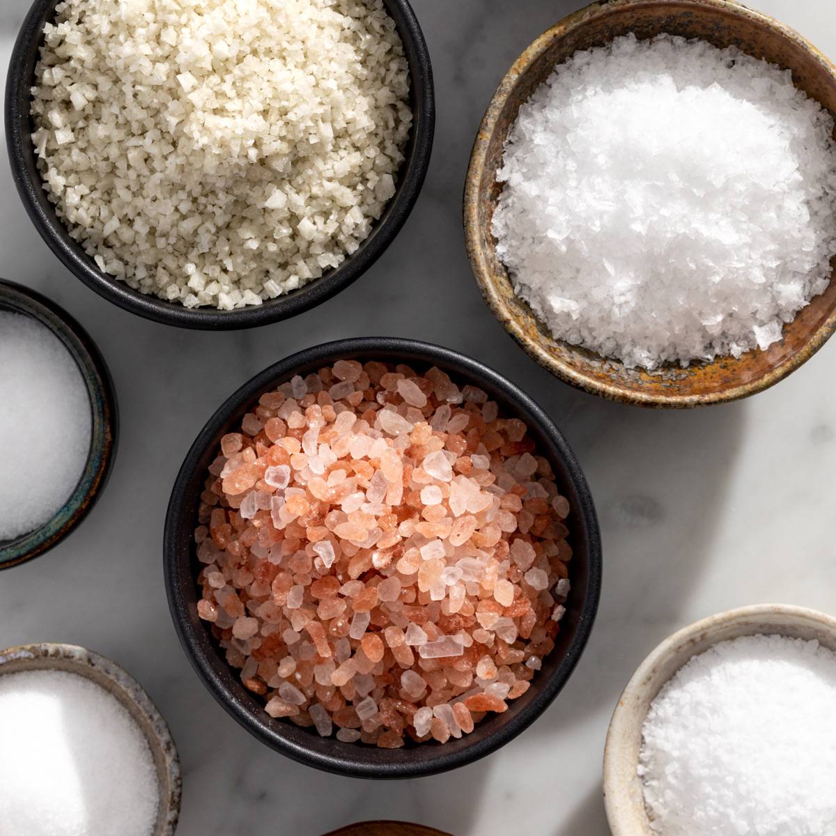 Small bowls holding different types of salt.