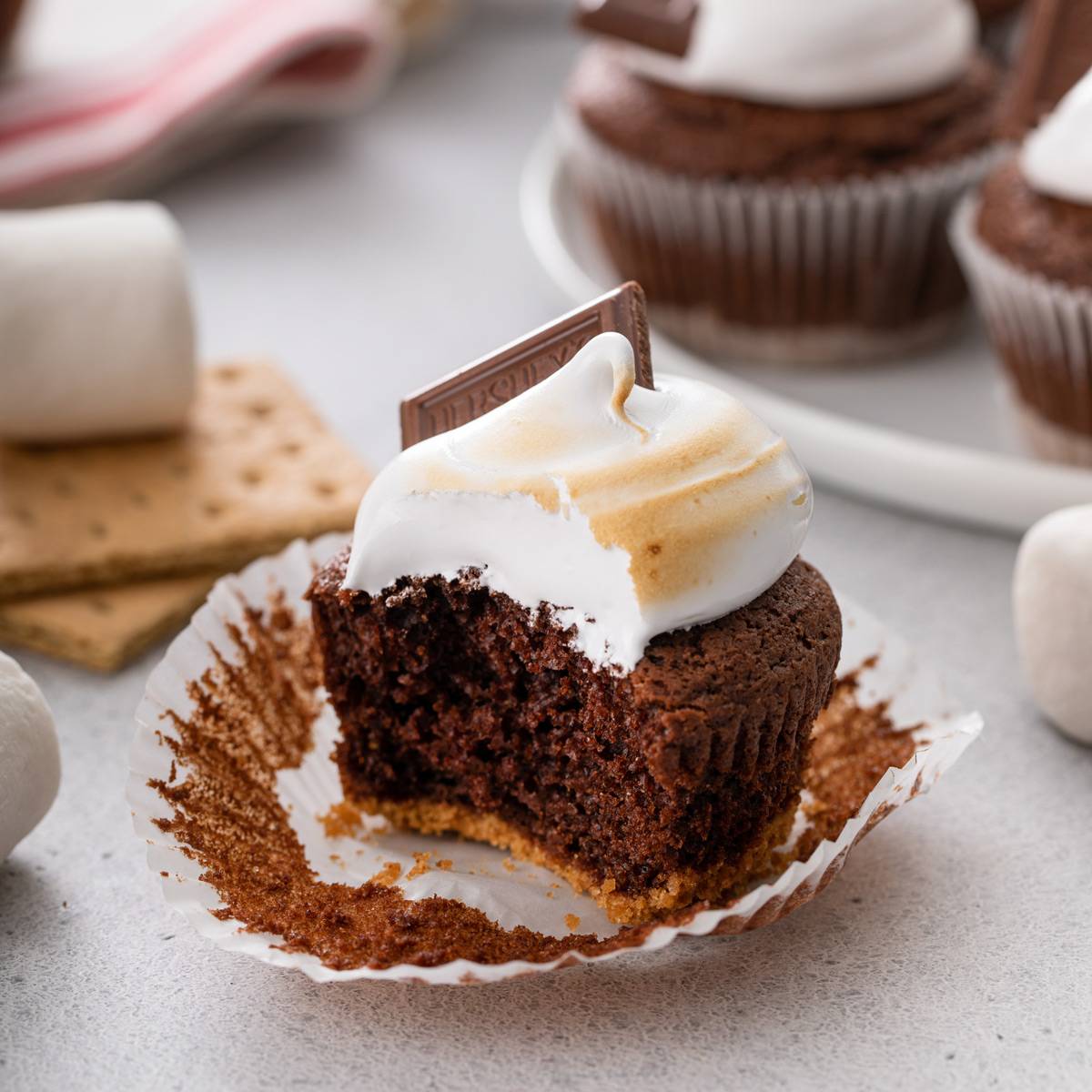 Unwrapped s'mores cupcake with a bite taken out of it.