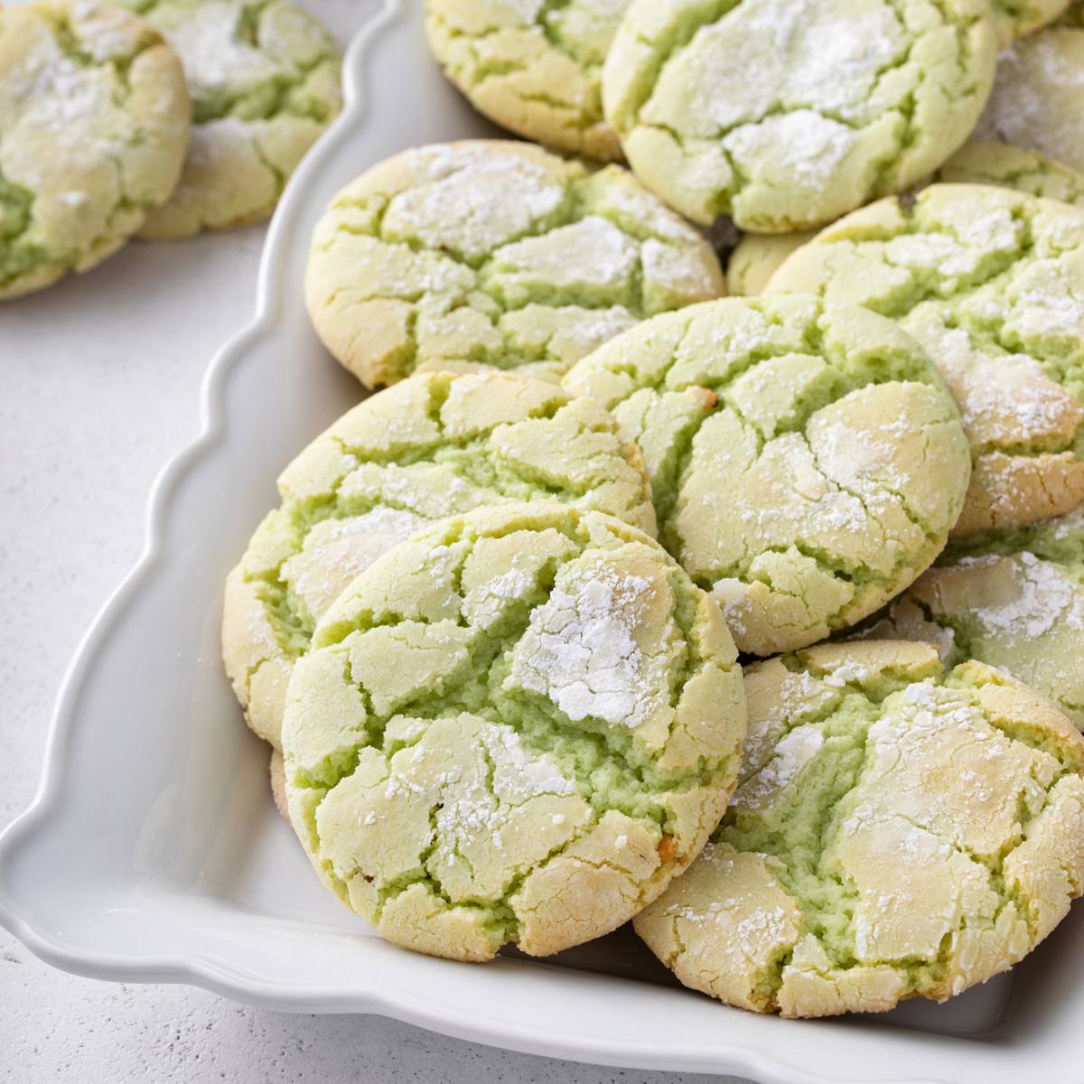 White platter filled with green crinkle cookies.
