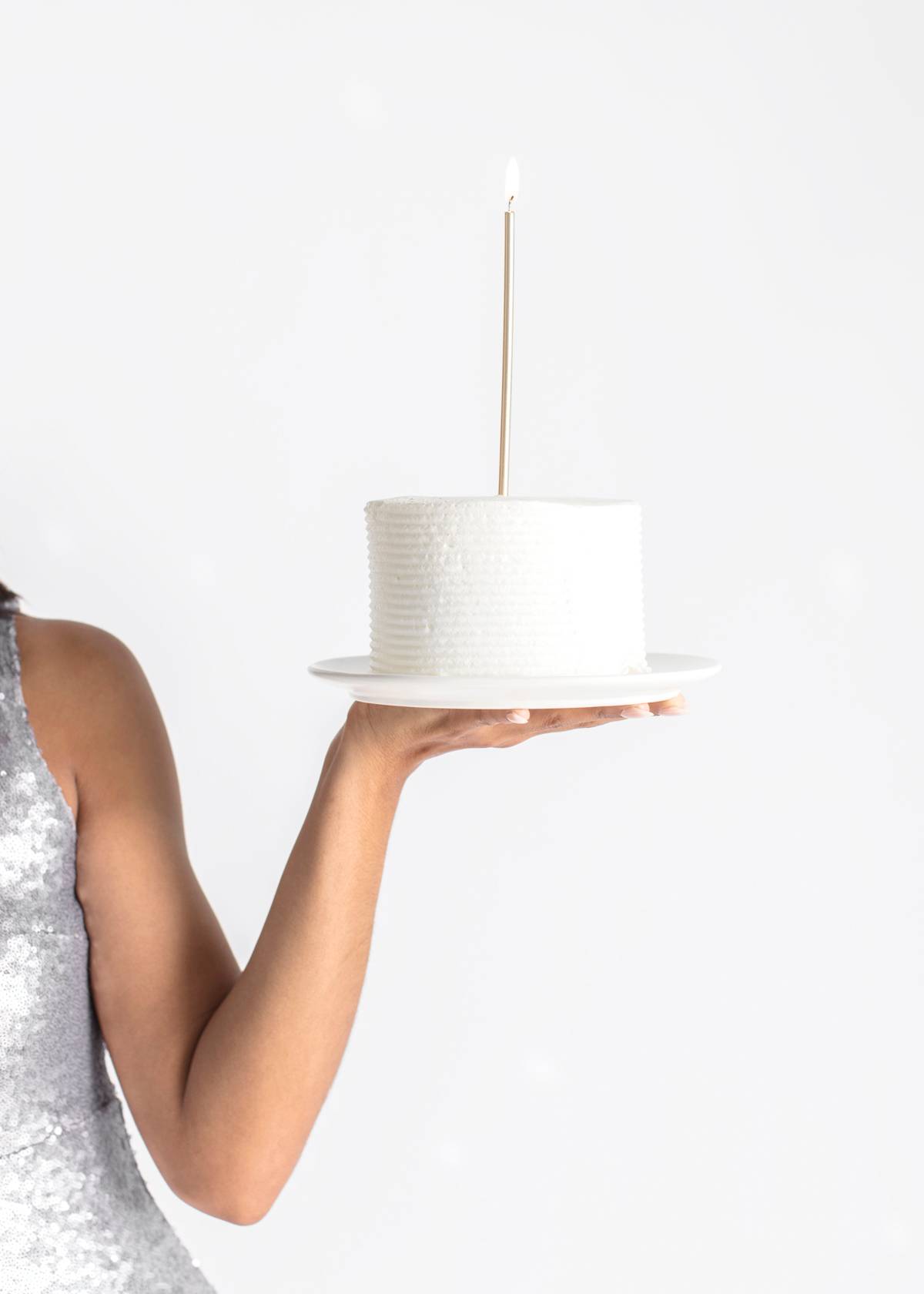 a woman holding a plated cake