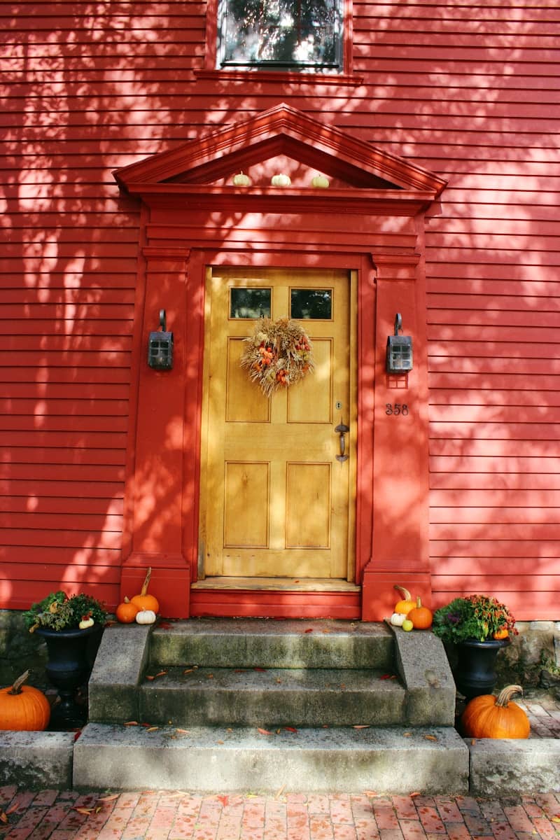 Red house with yellow door and autumn decorations