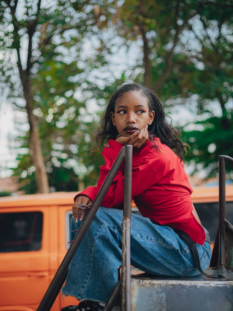Young woman in red shirt and jeans looking away