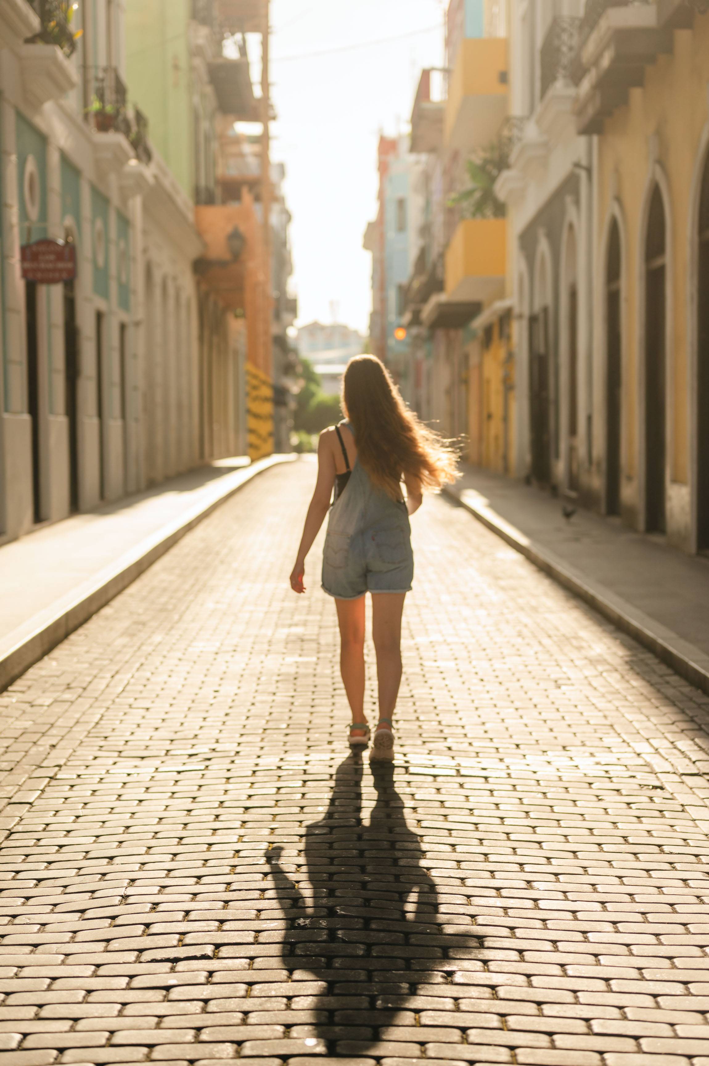 woman walking on a brick pathway 