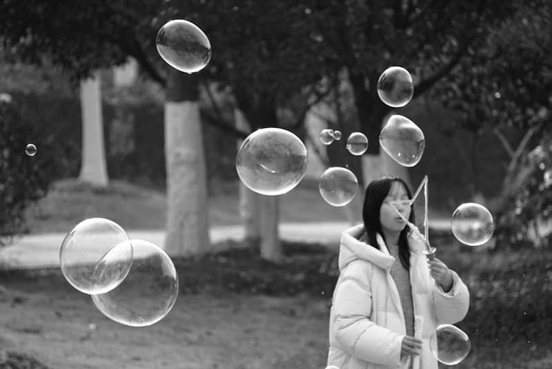 A young woman blowing bubbles outdoors in a park